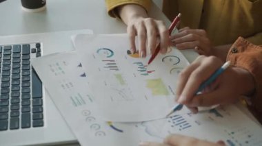 Finans raporlarını tartışan yöneticilerin elleri. İki iş noktası. Bir kalem üst üste. Toplantıda rapor ver veya ofiste pazarlık yap..