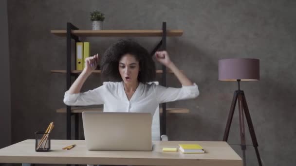 喜びに満ちたアフリカ系アメリカ人の女性は ラップトップで自宅の机を見て座って 興奮した出産の男性は コンピュータ上で良いニュースを読んで陶酔感の勝利を感じる 報酬の概念 — ストック動画