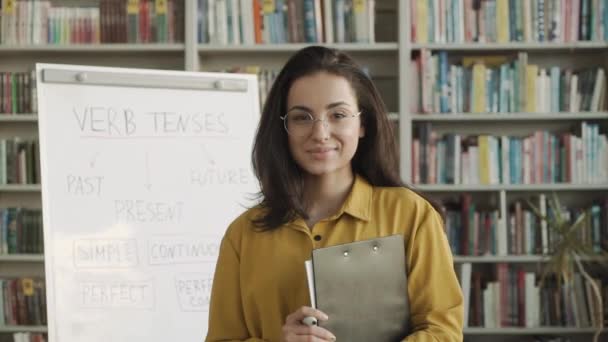 Młoda Kobieta Angielski Nauczyciel Patrząc Kamerę Klasie Biblioteka — Wideo stockowe