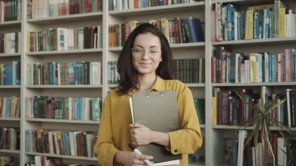 Fiatal Lány Diák Nézi Kamera Könyvtárban — Stock videók