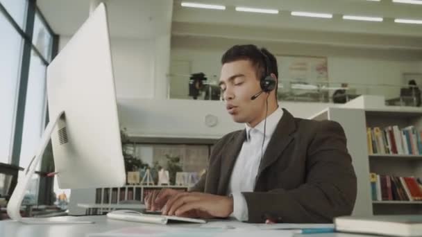 Operator Obsługi Klienta Słuchawkami Głośnomówiącymi Pracujący Biurze Mieszany Pracownik Wyścigowy — Wideo stockowe