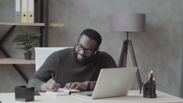 Сосредоточенный Афроамериканец Носит Современные Наушники Bluetooth Занимается Учебой Ноутбуком Концентрированный — стоковое видео