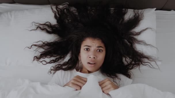 恐怖滑稽的非洲裔美国女孩躺在床上 满脸是毛毯 吓得面无血色 — 图库视频影像