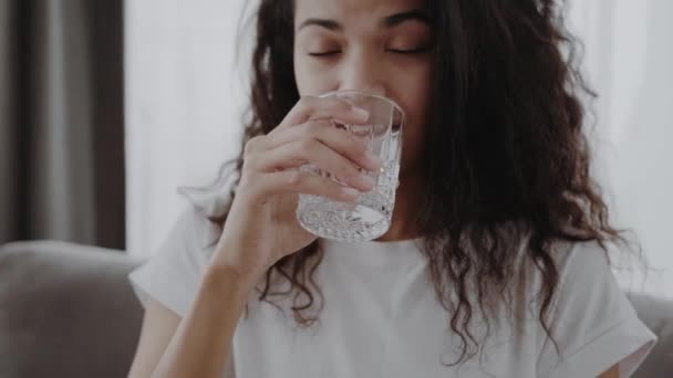 Здоровая Жидкость Улыбающаяся Черная Женщина Пьет Воду Стекла Смотрит Сторону — стоковое видео