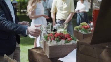 Erkek eli dışarıdaki yemek servisinde bardağa limonata doldurur..