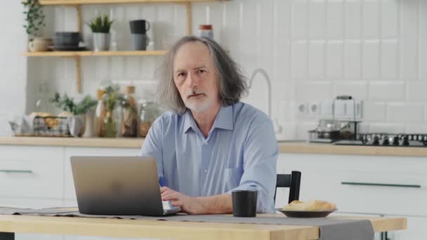 Starzejący Się Pracownik Skoncentrowany Starszy Mężczyzna Okularach Pracuje Laptopie Domowego — Wideo stockowe
