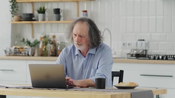 台所のノートパソコンの近くで老人を動揺させた オンラインサービスの問題悪いニュース大きな請求書 — ストック動画
