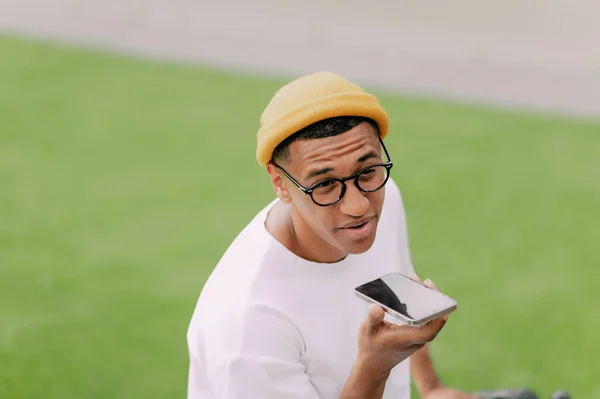 Feliz Jovem Hipster Está Sentado Parque Falando Telefone Com Sorriso — Fotografia de Stock