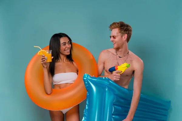 Pool Party Fun Multiethnic Couple Inflatable Rings Having Fun Shooting — Stock Photo, Image