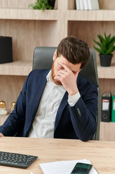 an executive or an office worker closing his eyes from the tiredness, and headache and migraine