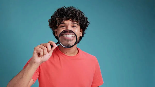 Legrační Indián Muž Ukazuje Bílé Zuby Usmívá Přes Lupu Korálové — Stock fotografie