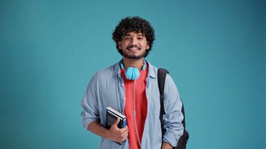 Mavi arka planda Hintli erkek öğrenci portresi