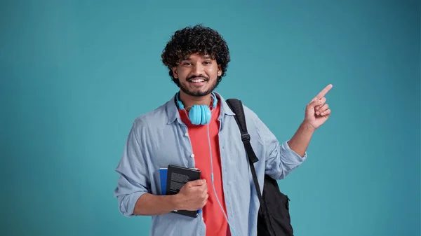 インドの学生男絶縁上の青の背景とともにバックパック上の肩ポイントとともに手で場所のためにテキスト — ストック写真