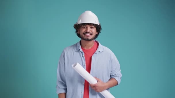 印度或阿拉伯裔年轻建筑师 头戴安全帽 对孤立的背景持蓝图 庆祝获奖者的胜利 — 图库视频影像