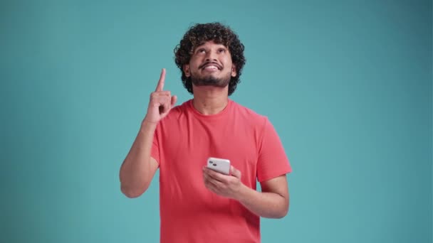 Akıllı Telefon Kullanan Genç Latin Adam Mavi Stüdyo Arka Planında — Stok video