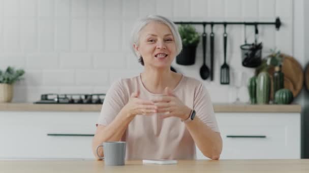 Glad Mogen Blond Dam Sitter Soffan Håller Videosamtal Med Vänner — Stockvideo