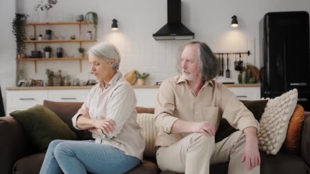 思慮深い高齢者の夫婦別のソファの上に座って フラストレーションを感じて口論の後に動揺して座っている 成熟した配偶者間の誤解 関係の危機 嫉妬の概念 — ストック動画