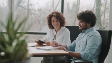 Hindistanlı yönetici CEO 'yu gündelik olarak dinleyen mutlu, genç, Afro-Amerikan iş kadını. Çeşitli çok ırklı profesyonel gruplar yönetim kurulu toplantısında iş planını tartışıyor..