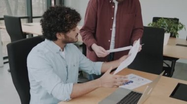 Çağdaş ofiste laptopla konuşmayı planlayan iki farklı iş adamı. Çok ırklı yönetim heyeti masada mali raporu tartışıyor.