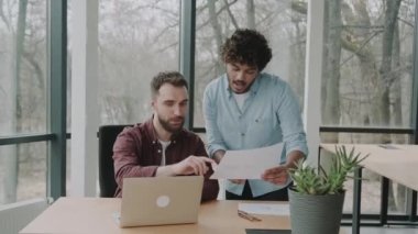 Günümüz ofisinde laptopla konuşan iki farklı gündelik planlama çalışanı. Çok ırklı yönetim heyeti masada mali raporu tartışıyor.