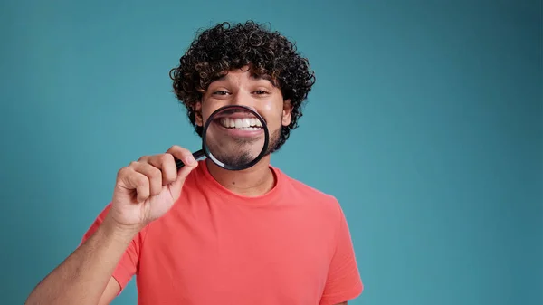 Смешной Латинский Арабский Мужчина Показывает Белые Зубы Улыбается Через Увеличительное — стоковое фото