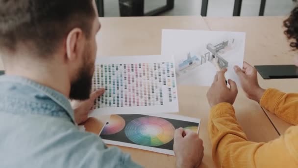 Два Дизайнера Держат Бумаги Проектом Квартиры Цветовой Палитрой Обсуждают Проект — стоковое видео