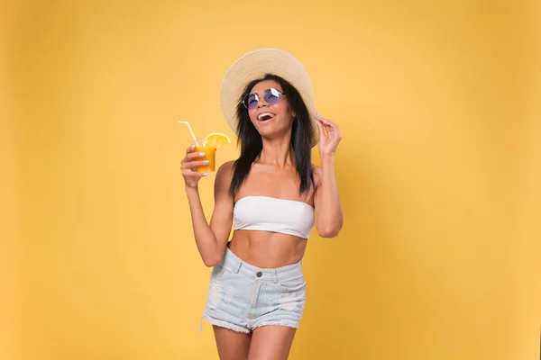 幸せなアフリカ系アメリカ人の女性が夏の服を着てカクテルを楽しんで飲んでいます 夏のビーチホリデーのコンセプト 黄色の背景に隔離され ロイヤリティフリーのストック写真