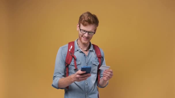 Young Bearded Man Glasses Holds Credit Card Smartphone Isolated Orange — Stock Video