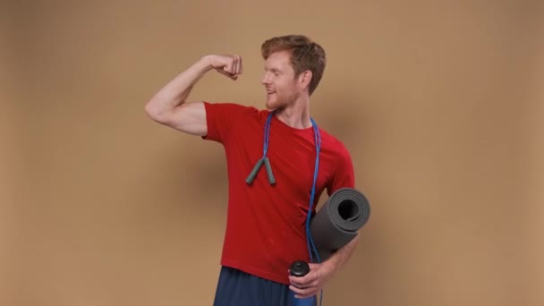 Grappige Jongeman Sportkleding Show Biceps Geïsoleerd Beige Achtergrond — Stockvideo
