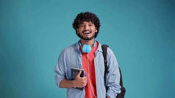 ラテン系スペイン人の男学生バックパックを肩に上の青いスタジオの背景 — ストック写真