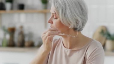 Yaklaş. Gri saçlı güzel bir kadının gözlerinde acı ve yorgunluk hissetmesini, gözlüğünü çıkarmasını ve gözlerini ovmasını diliyorum.