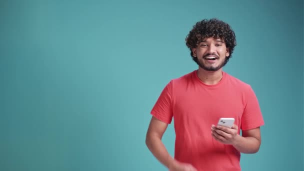 Feliz Hombre Indio Asombrado Sosteniendo Puntos Teléfono Celular Lado Aislado — Vídeos de Stock