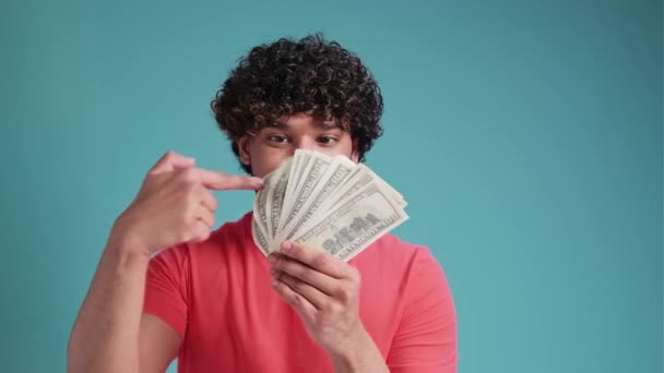 Молодий Іспаномовний Чоловік Посміхається Впевнено Покриває Рот Доларами Над Ізольованим — стокове відео