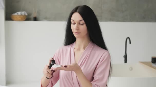 Mooie Jonge Brunette Vrouw Met Een Fles Lotion Schoonmaken Van — Stockvideo