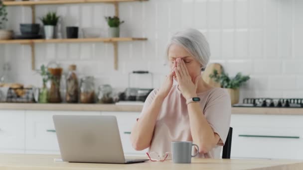 Літня Жінка Сидить Кухні Ноутбуком Вдома Відчуває Втому Біль Роздратованість — стокове відео