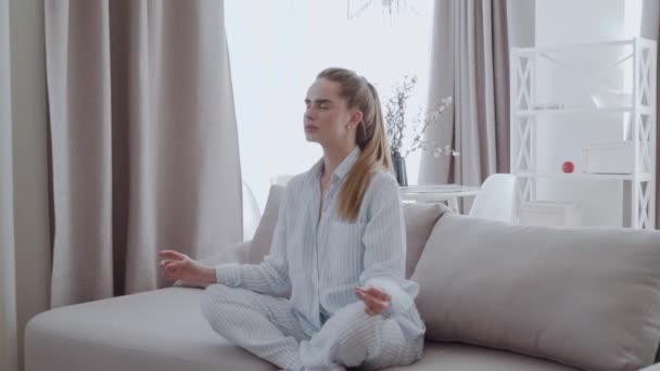 Vreedzame Jonge Vrouw Zitten Lotus Pose Sofa Woonkamer Mediteren Aantrekkelijk — Stockvideo