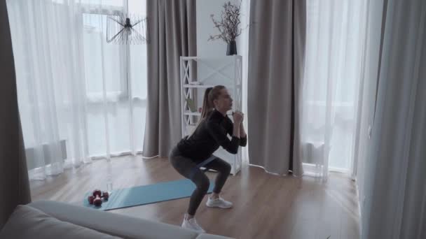 自宅でフィットネスエルフと若い美しいスポーツアスレチック女性スクワット — ストック動画
