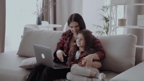 快乐的母亲和女儿挥手看着网络摄像头 用笔记本电脑进行视频通话 通过应用程序进行视频监控 — 图库视频影像