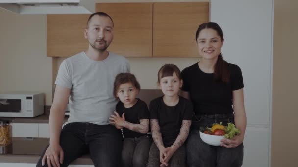 Heureux Famille Dans Cuisine Assis Sur Table Avec Bol Légumes — Video