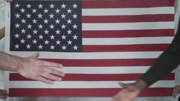 白人と黒人の友好関係 アメリカ国旗の背景にある黒人と白人の握手 — ストック動画
