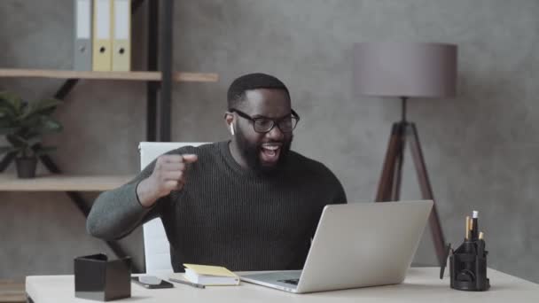 Coşkulu Siyahi Öğrenci Masada Oturup Dizüstü Bilgisayarın Çığlık Atmasına Bakar — Stok video