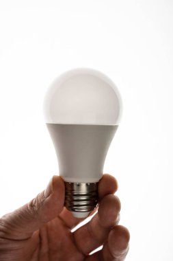 Adamın biri bir LED ampulü tutuyor. Enerji tasarrufu LED ampulü.