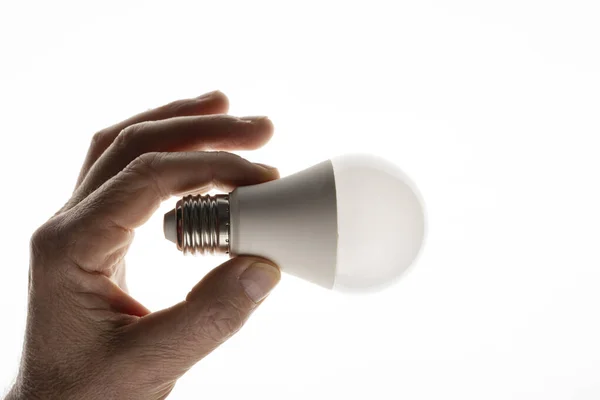 stock image A man is holding an LED light bulb. Energy saving LED bulb.