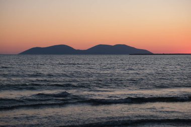 Gün batımında gökyüzü ve bulutların arasında güneş olan sakin bir deniz. Meditasyon okyanusu ve gökyüzü arka planı. Huzurlu deniz manzarası. Suyun üzerinde ufuk çizgisi. Yüksek kalite fotoğraf