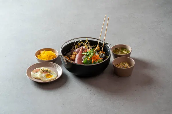 Korean food dish Stir-fried cartilage rice ball, seafood fish cake soup, boiled pork, tofu, kimchi, and stir-fried pork
