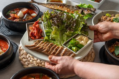 Kore yemek menüleri yanında domuz etli menü, haşlanmış balık, soya peyniri, kızarmış tavuk ve marine edilmiş sığır pirzolası.