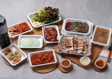 Kore yemeği, domuz ayağı, haşlanmış domuz eti, bossam, sarımsak, kırmızı biber, marul, ssamjang, makguksu, hamur tatlısı.