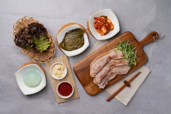 stock image Korean food, briquettes, bulgogi, red pepper paste, pork, pork belly, side dishes, garlic, lettuce, vegetables, seasoning