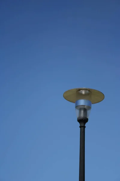 The photo shows a street lamp with a clear sky. In the style of minimalism.