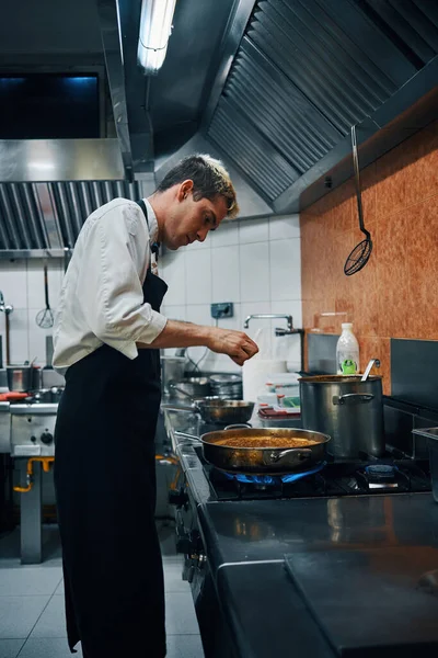 stock image chef cooking with pan on fire, professional cuisine